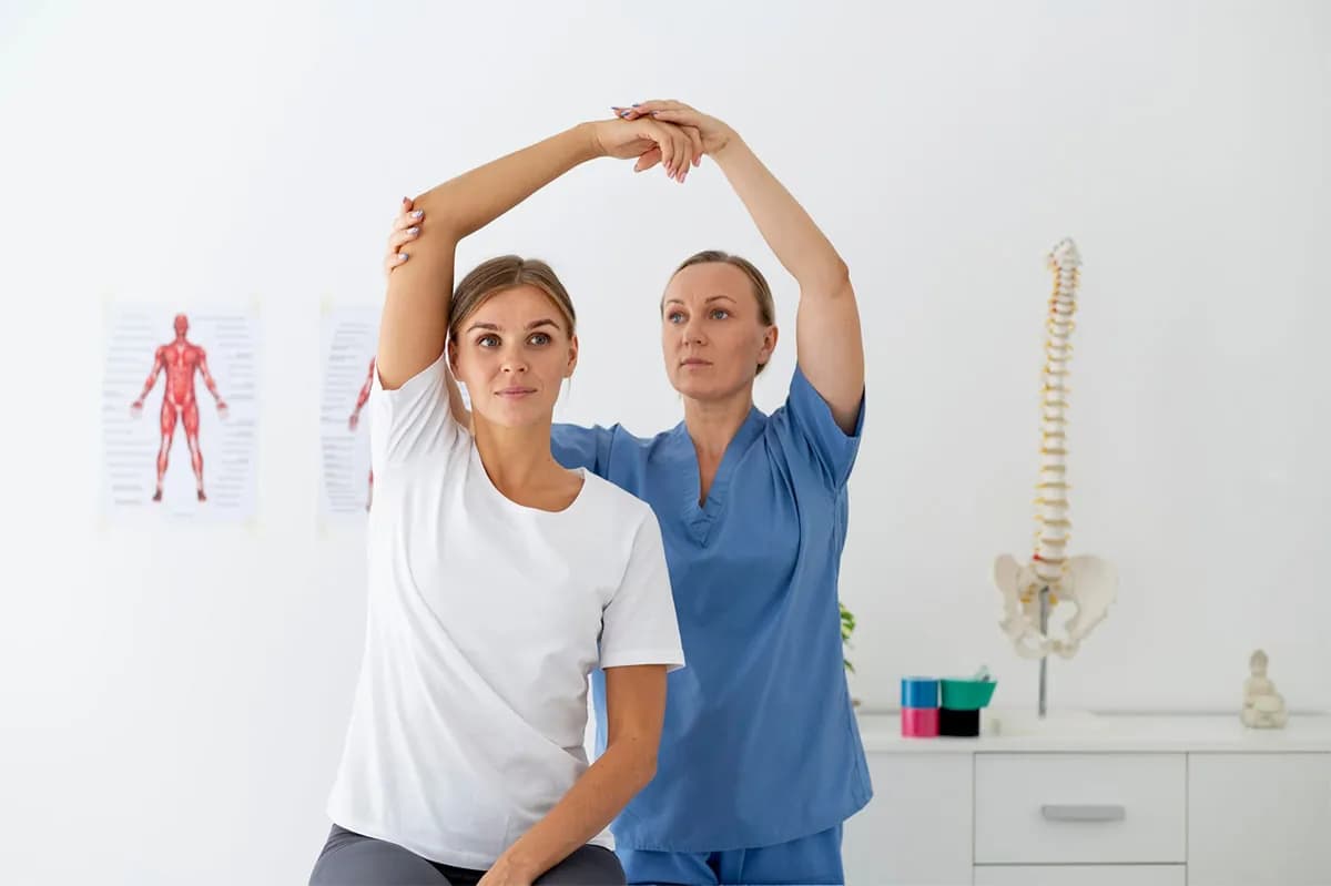 Physiotherapist and patient doing an overhead stretch together in a clinic