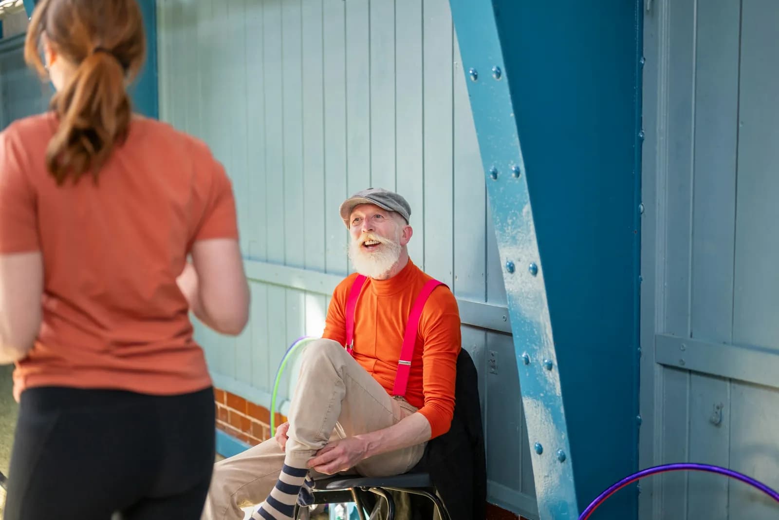 Smiling older man talking with a coach in a community gym