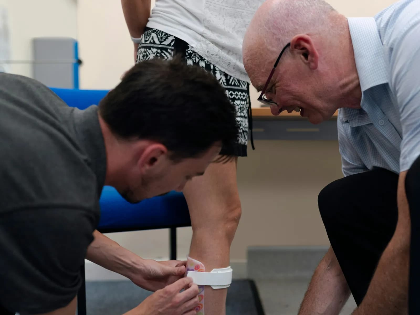 Clinician assessing an older man's foot and ankle